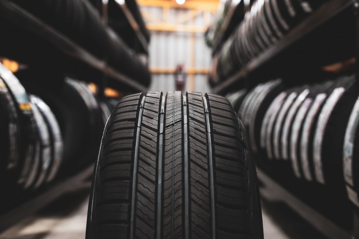A new tyre being placed on the storage rack in a car workshop