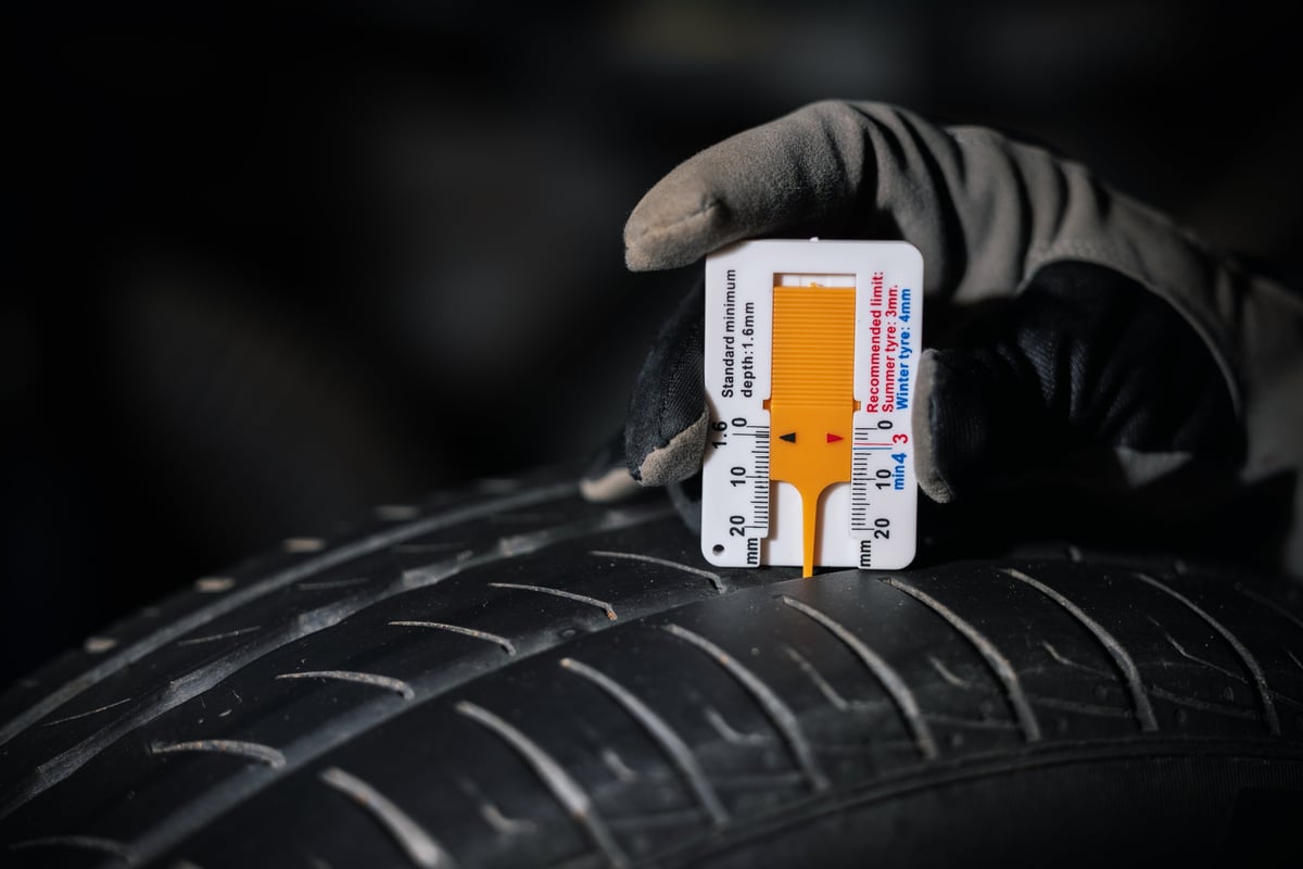 Close-up of a car tyre tread pattern with the tread depth being checked