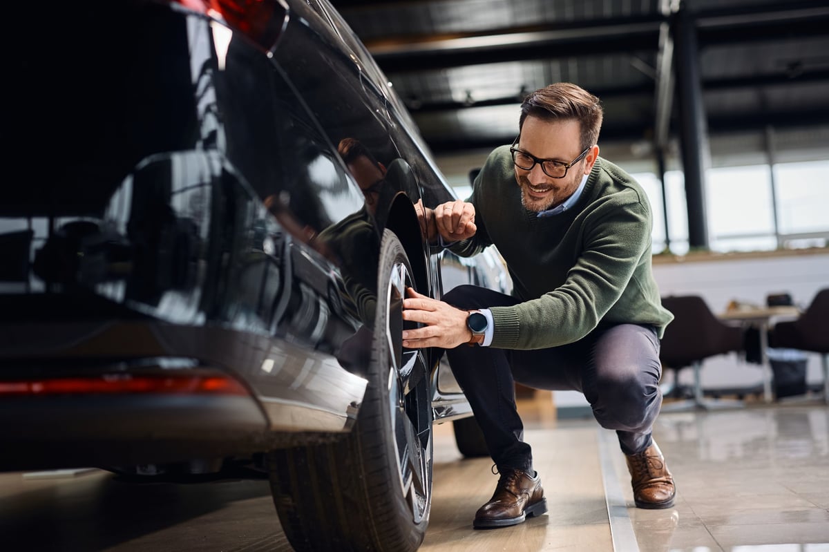 Customer looking at tyres on a vehicle in a showroom